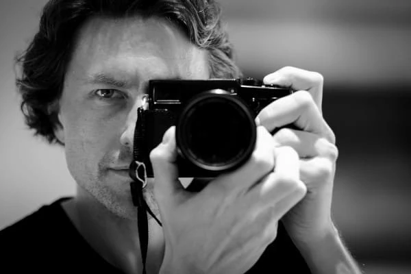 Retrato aproximado de um homem fotografando através da câmera